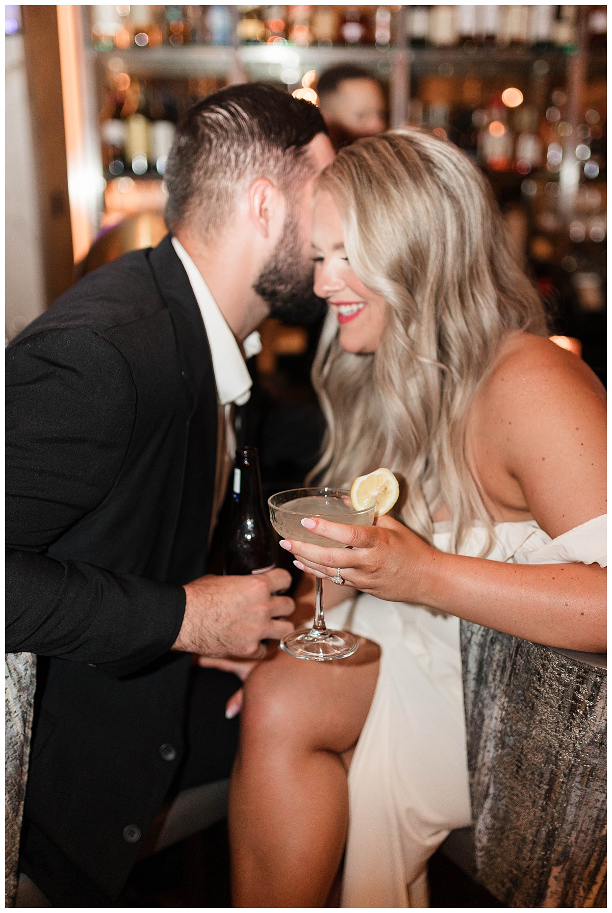 a couple with drinks in front of a bar